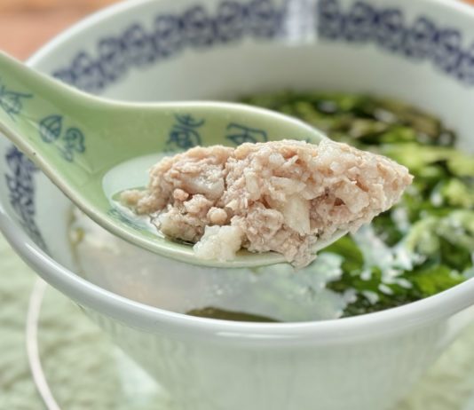 レンゲですくい上げた、長芋と豚ひき肉の澄まし蒸しスープ（山薬肉餅湯）